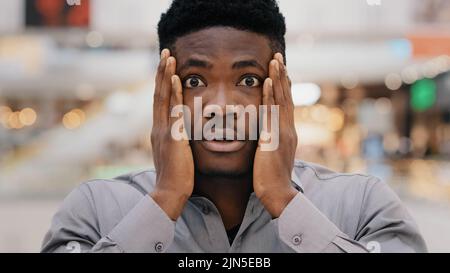Nahaufnahme männlich Porträt jung überrascht verblüfft aufgeregt schockiert ernsten afroamerikanischen Mann hält Hände auf Gesicht Überraschung sagen wow bekommen Stockfoto