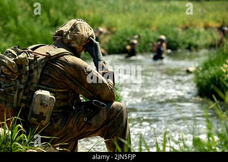 Soldiers Spiel auf militärischem Trainingsgelände, Kampflager. Aktion. Operation Trainer, der die Militärsoldaten im Bootcamp trainiert Stockfoto