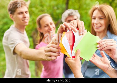 Das Team junger Menschen zieht beim Team Building Game Karten, um sich beim Team Event kennenzulernen Stockfoto