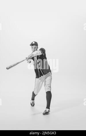 Portrait von jungen Mann, Baseballspieler, Teig bereit, Ball mit Fledermaus zu schlagen. Schwarzweiß-Fotografie Stockfoto