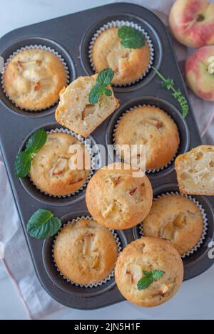 Süße hausgemachte Vanillepfirsich-Muffins auf einem Tisch Stockfoto