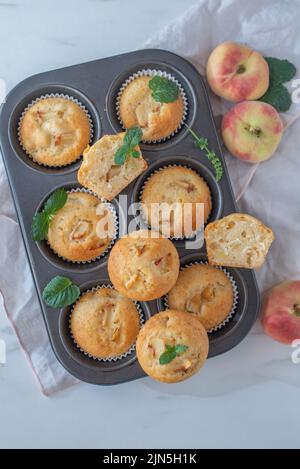Süße hausgemachte Vanillepfirsich-Muffins auf einem Tisch Stockfoto
