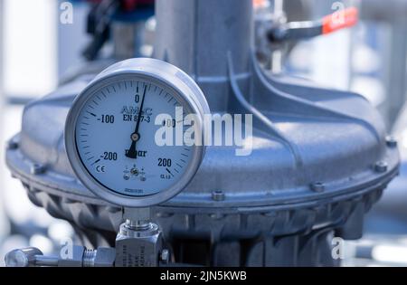 Darchau, Deutschland. 09. August 2022. In der ersten kompakten Bio-LNG-Anlage auf dem Gelände des Landwirtschaftsverbands Darchau wird nach Angaben des Herstellers ein Manometer installiert. In Zukunft wird die Anlage in der Lage sein, im Inland produzierten grünen Kraftstoff für den schweren Lkw- und Busverkehr zu liefern. Die Anlage soll jährlich etwa 1,3 Millionen Liter fossilen Diesel ersetzen und bis zu 7.000 Tonnen CO2 einsparen. Quelle: Jens Büttner/dpa/Alamy Live News Stockfoto