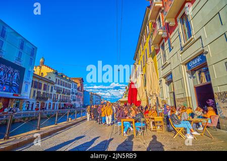 MAILAND, ITALIEN - 9. APRIL 2022: Die angenehme Abendzeit steht am 9. April in einem der Freiluftcafés am Naviglio Grande Canal in Mailand, Italien, bevor Stockfoto