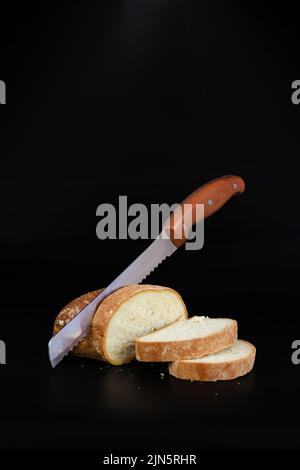 Küchenmesser aus Metall schneidet Brot auf Schneidebrett Stockfoto