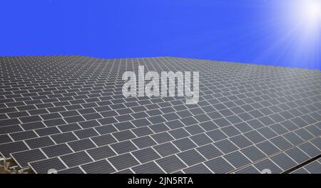 Große Oberfläche von Sonnenkollektoren am blauen Himmel, Photovoltaik-Solarzellen Energiepark für die Produktion von sauberer erneuerbarer Energie aus den Sonnenstrahlen Stockfoto