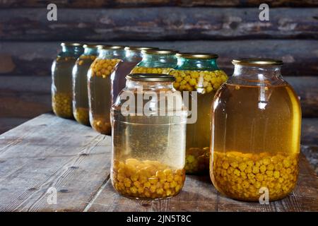 Moltebeere Hauskonservendosen, Gläser Beerenkompott sind auf dem Tisch in der Scheune. Stockfoto