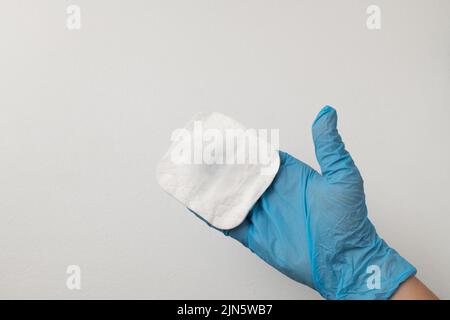 Hadn hält weiße Watteschwämme auf weißem Hintergrund. Design für die Kosmetik-, Medizin- und Kosmetikindustrie Hygieneartikel auf weißem Hintergrund. Der Stockfoto