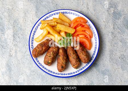 Traditionelle türkische Küche; trockene Fleischbällchen oder Inegöl-Fleischbällchen mit Kartoffeln und Reis pilav (türkischer Name; Kuru kofte) Stockfoto