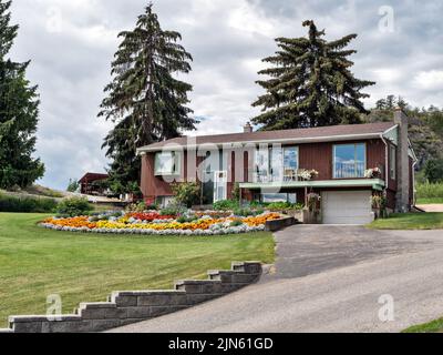 Altes Wohnhaus in Kanada mit großem Blumenbeet auf dem Vorgarten Stockfoto