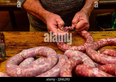 Hände arbeiten an der Herstellung von Würsten, traditionelle argentinische Schlachtung. Stockfoto