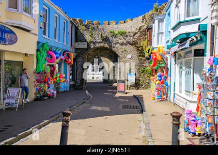 Farbenfrohe Schaufel- und Spatengeschäfte neben der historischen Stadtmauer in Five Arches in der St George's Street, Tenby, Pembrokeshire, Wales, Großbritannien Stockfoto