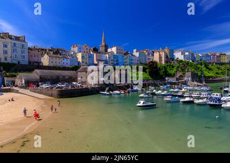 Der malerische geschützte Hafen wird von Reihen farbenfroher Häuser in Tenby, Pembrokeshire, Wales, Großbritannien, überblickt Stockfoto