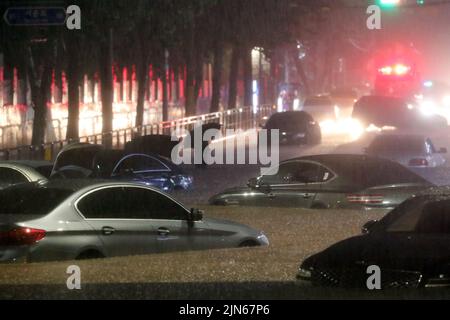SEOUL, 9. August 2022 (Xinhua) -- Fahrzeuge werden auf einer überfluteten Straße im Gangnam-Bezirk in Seoul, Südkorea, untergetaucht, 8. August 2022. Acht Menschen wurden getötet und sechs weitere wurden vermisst, als die südkoreanische Metropolregion von schweren Regenfällen heimgesucht wurde, teilte das zentrale Hauptquartier für Katastrophenschutz und Gegenmaßnahmen am Dienstag mit. Über 100 Millimeter Regen pro Stunde trafen am Montagabend in der Hauptstadt Seoul, der westlichen Hafenstadt Incheon und der Provinz Gyeonggi, die Seoul umgibt, ein. (NEWSIS über Xinhua) Stockfoto