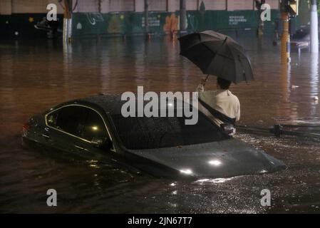 SEOUL, 9. August 2022 (Xinhua) -- Fahrzeuge werden auf einer überfluteten Straße im Gangnam-Bezirk in Seoul, Südkorea, untergetaucht, 8. August 2022. Acht Menschen wurden getötet und sechs weitere wurden vermisst, als die südkoreanische Metropolregion von schweren Regenfällen heimgesucht wurde, teilte das zentrale Hauptquartier für Katastrophenschutz und Gegenmaßnahmen am Dienstag mit. Über 100 Millimeter Regen pro Stunde trafen am Montagabend in der Hauptstadt Seoul, der westlichen Hafenstadt Incheon und der Provinz Gyeonggi, die Seoul umgibt, ein. (NEWSIS über Xinhua) Stockfoto
