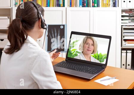 Telemedizinisches Konzept: Zwei Ärzte oder Apotheker während einer medizinischen Videokonferenz über Röntgenergebnisse. Stockfoto