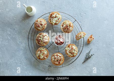 Miniportionen von Flammekueche oder Flammkuchen, französische und deutsche Spezialität, auf dem runden Kühlgitter aus Metall, Draufsicht Stockfoto