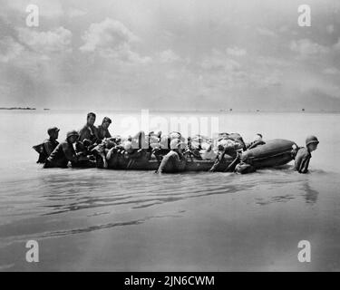 TARAWA, PAZIFISCHER OZEAN - November 1943 - US-amerikanische Marines, die bei der Landung auf Tarawa verwundet wurden, werden von ihren Freunden auf Gummibooten zu größerer Weite abgeschleppt Stockfoto