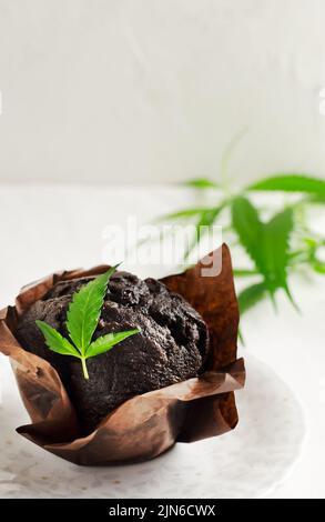 Marihuana Cupcake Muffins mit Cannabisblättern. Glutenfrei. Alternative Süßwaren-Konzept. Vertikale Ausrichtung. Selektiver Fokus. Stockfoto