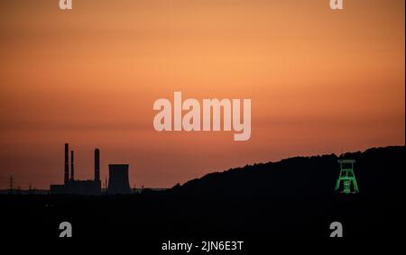 Bottrop, Deutschland. 08. August 2022. Der Grubenvorarbeiter der Kolonie Prosper Haniel wird bei Sonnenuntergang beleuchtet. Quelle: Fabian Strauch/dpa/Alamy Live News Stockfoto