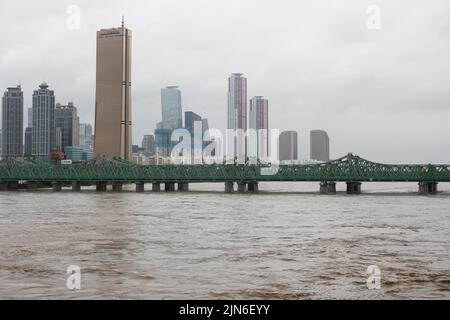 Seoul, Südkorea. 9. August 2022. Das am 9. August 2022 aufgenommene Foto zeigt den überfließenden Han-Fluss aufgrund der starken Regenfälle in Seoul, Südkorea. Acht Menschen wurden getötet und sechs weitere wurden vermisst, als die südkoreanische Metropolregion von schweren Regenfällen heimgesucht wurde, teilte das zentrale Hauptquartier für Katastrophenschutz und Gegenmaßnahmen am Dienstag mit. Über 100 Millimeter Regen pro Stunde trafen am Montagabend in der Hauptstadt Seoul, der westlichen Hafenstadt Incheon und der Provinz Gyeonggi, die Seoul umgibt, ein. Quelle: Wang Yiliang/Xinhua/Alamy Live News Stockfoto