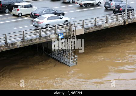 Seoul, Südkorea. 9. August 2022. Fahrzeuge fahren auf einer Straße neben dem überfließenden Han-Fluss, verursacht durch heftige Regenfälle in Seoul, Südkorea, 9. August 2022. Acht Menschen wurden getötet und sechs weitere wurden vermisst, als die südkoreanische Metropolregion von schweren Regenfällen heimgesucht wurde, teilte das zentrale Hauptquartier für Katastrophenschutz und Gegenmaßnahmen am Dienstag mit. Über 100 Millimeter Regen pro Stunde trafen am Montagabend in der Hauptstadt Seoul, der westlichen Hafenstadt Incheon und der Provinz Gyeonggi, die Seoul umgibt, ein. Quelle: Wang Yiliang/Xinhua/Alamy Live News Stockfoto