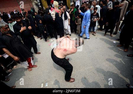 Peshawar, Khyber Pakhtunkhwa, Pakistan. 8. August 2022. Schiitische Muslime geißeln sich während der Prozession zum Ashura-Tag in Peshawar, Pakistan, am 08. August 2022. Schiitische Muslime beobachten den heiligen Monat Muharram, dessen Höhepunkt das Aschura-Fest ist, das an das Martyrium von Imam Hussein, einem Enkel des Propheten Mohammed, in der Schlacht der irakischen Stadt Karbala im siebten Jahrhundert erinnert. (Bild: © Hussain Ali/Pacific Press via ZUMA Press Wire) Stockfoto