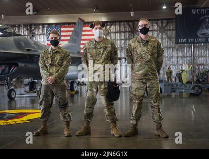 US Air Force Staff Sgt. David Botterill (links), Chef des Waffenladerteams, Airmen 1. Class Braedon Sauer (Mitte) und Cole Rounds (rechts), Mitglieder des Waffenladerteams der 13. Aircraft Maintenance Unit, stehen während des Lastwettbewerbs im zweiten Quartal auf der Misawa Air Base, Japan, 16. Juli 2021 vor einem F-16 Fighting Falcon. Drei Mitglieder benötigen die Vorbereitung des Flugzeugs, die Checkliste der technischen Aufträge und die Anbringung der Waffen am Flugzeug während des Ladewettbewerbs so effizient wie möglich. (USA Luftwaffe Foto von Airman 1. Klasse Leon Redfern) Stockfoto