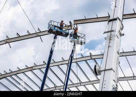 Gebäudekonstruktion mit Stahlträgern und Arbeiten in der Höhe Stockfoto