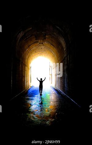 Einzelne Person am Ende des Tunnels für Erfolg und Triumph am Ende der Reise Stockfoto