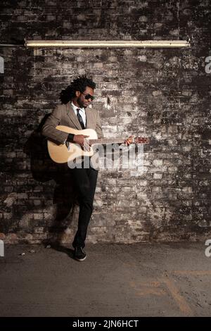 Der Busker. Ein elegant gekleideter Gitarrist auf seinem Buschplatz. Stockfoto