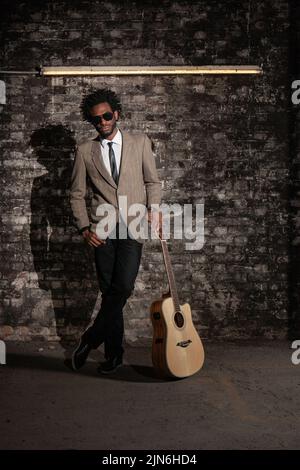 Der Busker. Ein elegant gekleideter Gitarrist auf seinem Buschplatz. Stockfoto