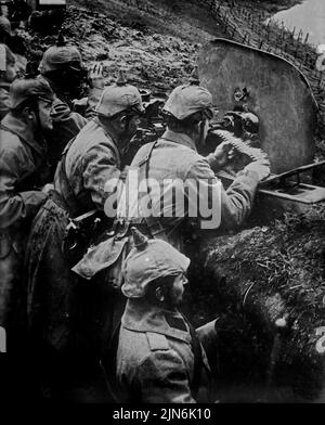 OSTFRONT, DEUTSCHLAND - um 1914 - Deutsche Infanteriesoldaten in einem Graben an der Ostfront mit einem Spandauer Maschinengewehr während des Ersten Weltkrieges -- Pictu Stockfoto