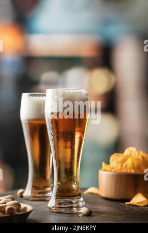 Zwei Gläser leicht schaumiges Bier mit Tropfen auf der Seite in der Bar. Alkohol, Unterhaltung, traditionelle Getränke, Oktoberfest-Atmosphärenkonzept. Speicherplatz kopieren. Stockfoto