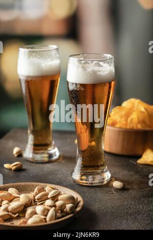 Zwei Gläser leicht schaumiges Bier mit Tropfen auf der Seite in der Bar. Alkohol, Unterhaltung, traditionelle Getränke, Oktoberfest-Atmosphärenkonzept. Speicherplatz kopieren. Stockfoto