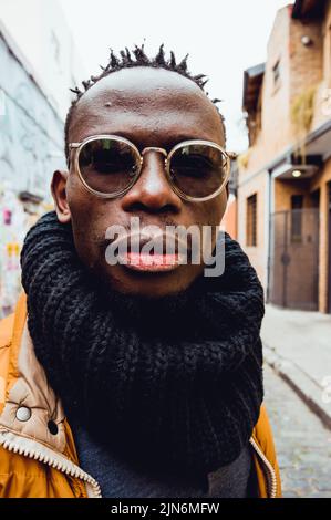 Nahaufnahme eines vertikalen Porträts eines ernsthaften afrikanischen Mannes im Freien Stockfoto