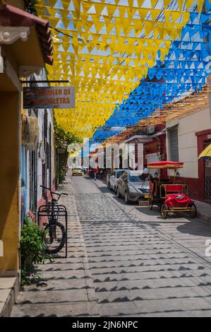 Die Straßen des coolen Viertels Getsemani sind mit farbigen Flaggen geschmückt, Cartagena de Indias, Kolumbien Stockfoto