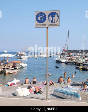 Covid Informationen Warnschilder am Positano Dorf Strand vor Italien zeigen Strand und Wasser im Hintergrund.Soziale Distanzierung und Masken. Stockfoto