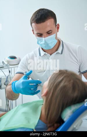 Stomatologe, der vor dem zahnärztlichen Eingriff Lokalanästhesie anwendet Stockfoto