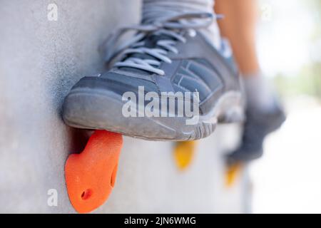 Nahaufnahme der Füße an einer Kletterwand Stockfoto