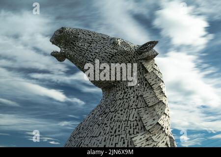 Falkirk, Vereinigtes Königreich - 20. Juni 2022: Eine der Kelpies-Pferdekopfskulpturen mit einem ausdrucksstarken, langbelichteten Himmel dahinter Stockfoto