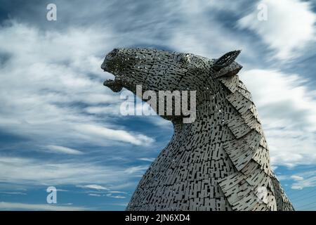 Falkirk, Vereinigtes Königreich - 20. Juni 2022: Eine der Kelpies-Pferdekopfskulpturen mit einem ausdrucksstarken, langbelichteten Himmel dahinter Stockfoto
