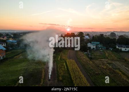 Luftaufnahme von Lagerfeuern von landwirtschaftlichen Abfällen durch trockenes Gras und Strohstoppel, die während der Trockenzeit auf Ackerland mit dichtem Rauch die Luft verschmutzen Stockfoto