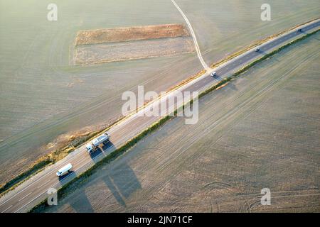 Luftaufnahme von Lastkraftwagen, die auf der Autobahn unterwegs waren. Transport- und Logistikkonzept Stockfoto
