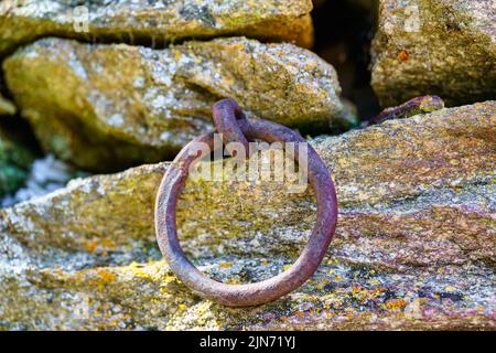 Gusseiserner Ring im Granitdamm zum Festmachen von Schiffen. Stockfoto