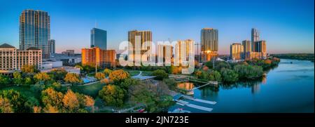 Austin, Texas – Stadtbild in der Nähe des Colorado River bei Sonnenuntergang. Es gibt hohe Gebäude auf der linken Seite mit Spiegelung des Sonnenuntergangs. Stockfoto