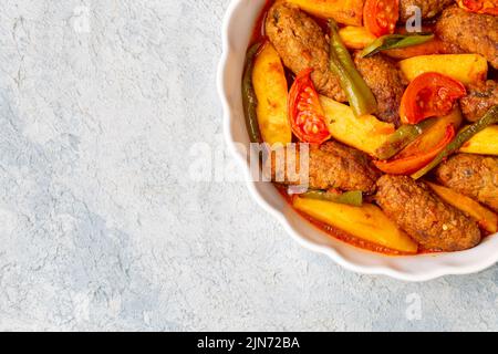 Traditionelle hausgemachte türkische Küche Kofte: Kofta mit Tomatensauce und Kartoffeln. (Türkischer Name; Izmir kofte) Stockfoto