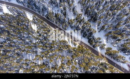 Luftaufnahme der verschneiten Winterlandschaft mit Drohne, Straße durch Wald mit verschneiten Bäumen, Bolu - Golcuk - Türkei Stockfoto