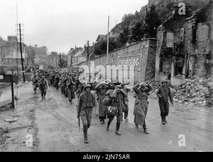 CHERBOURG, FRANKREICH - 28. Juni 1944 - Soldaten der US-Armee marschieren Kriegsgefangene der deutschen Armee aus Cherbourg, Frankreich, kurz nachdem sie die Stadt während der Normandie I besetzt hatten Stockfoto