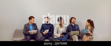 Multirassische Menschen Männer und Frauen warten in der Schlange für ein Interview in großen Unternehmen sitzt in der Nähe der Wand Stockfoto